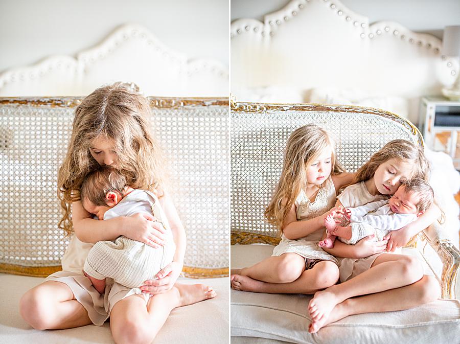 sister kissing newborn brother's head