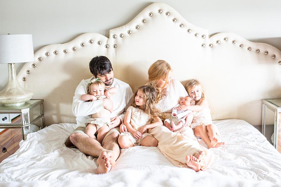 the whole family laying on a bed