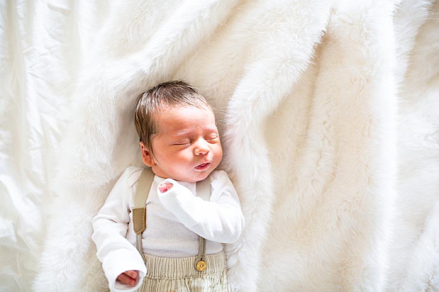 newborn laying on a fleece blanket