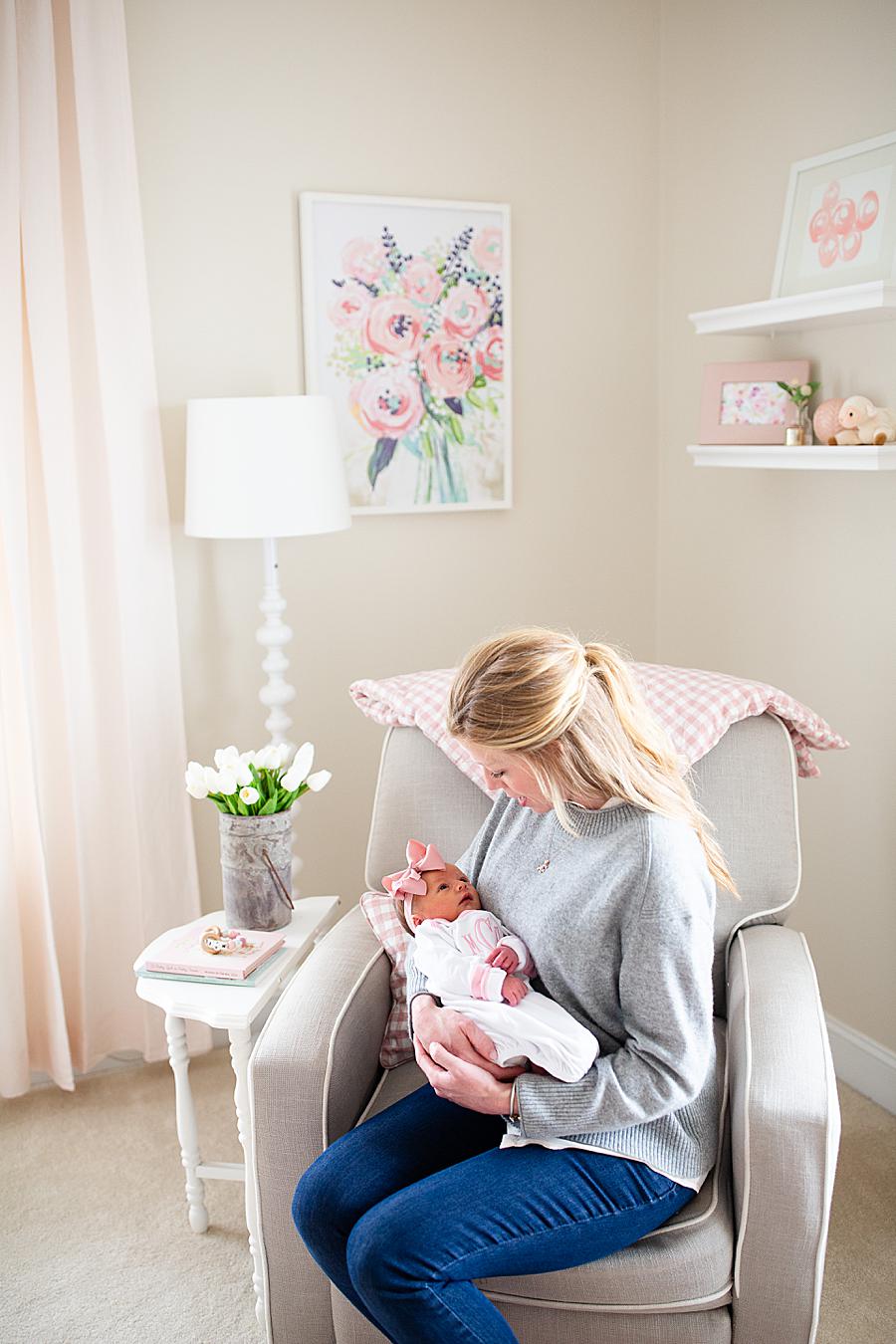 mom holding baby in nursery at newborn photo session