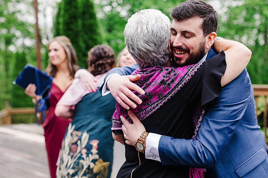 Groom hugging grandmother at rainy castleton farms wedding