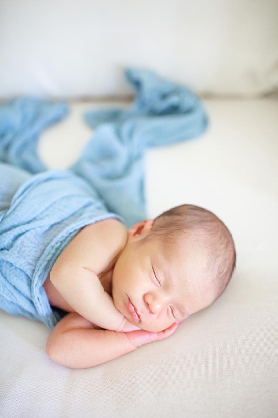 baby in blue swaddle