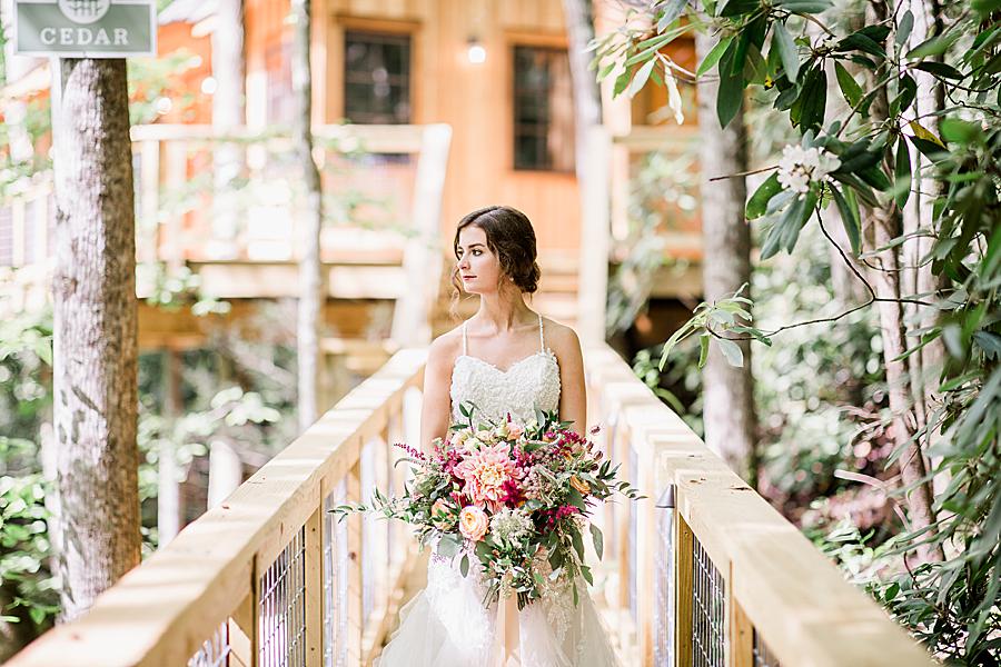 Bride on wooden bridge at Treehouse Grove styled shoot
