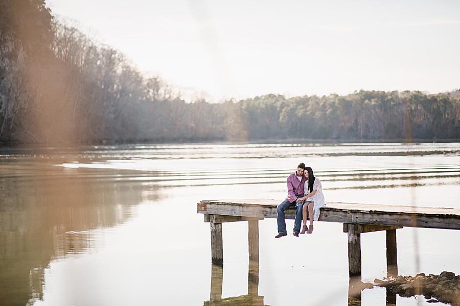 Sitting on a dock at their winter engagement at Melton Hill Park